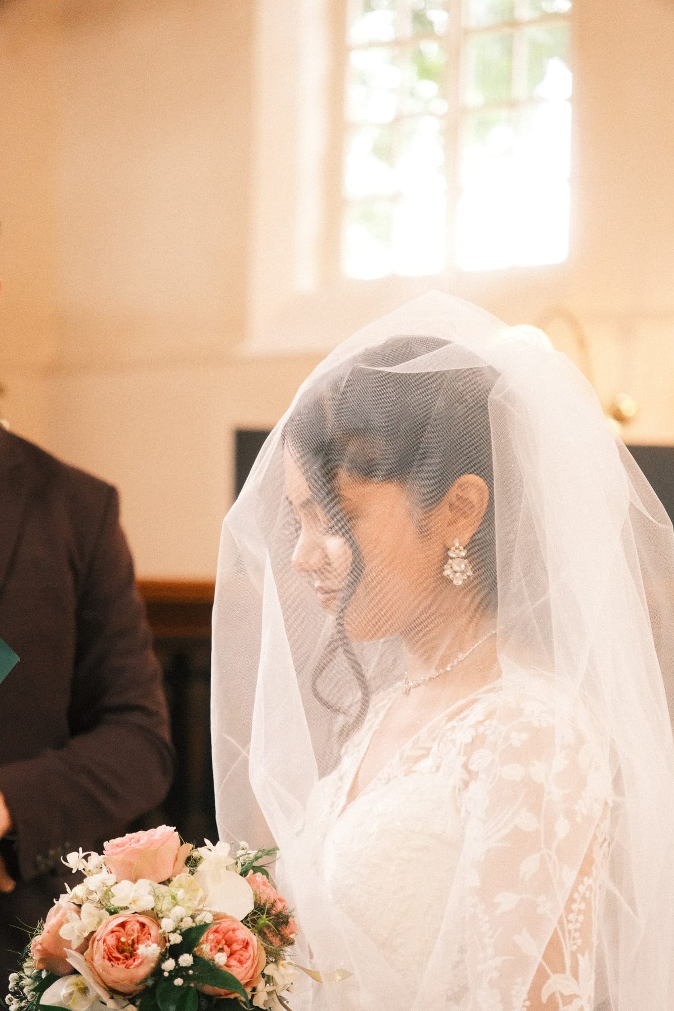 De bruid met sluier in tegenlicht, vlak voor de ceremonie
