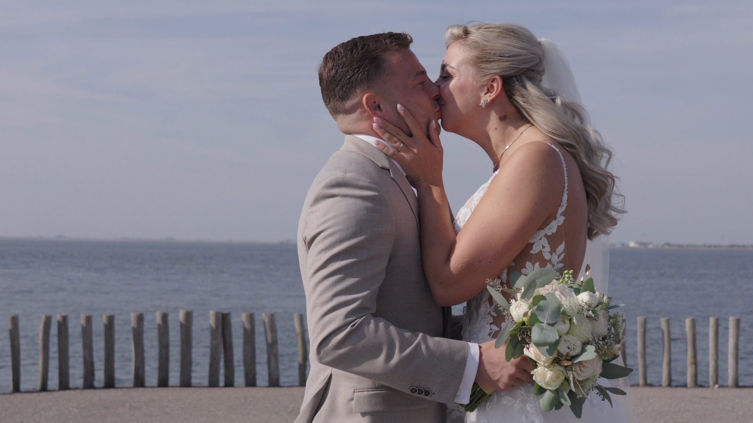 Romy en Marijn kussen elkaar aan zee, uit hun trouwfilm